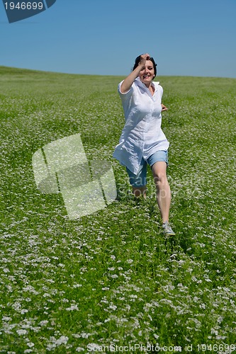 Image of Young happy woman in green field