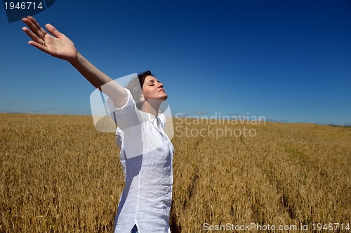 Image of young woman in wheat field at summer