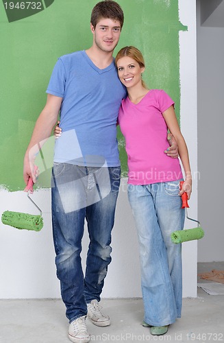 Image of happy couple paint wall at new home