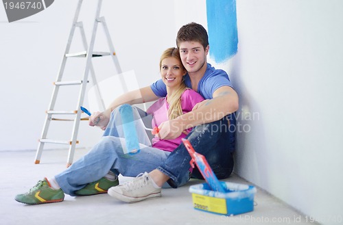 Image of happy young cople relaxing after painting in new home