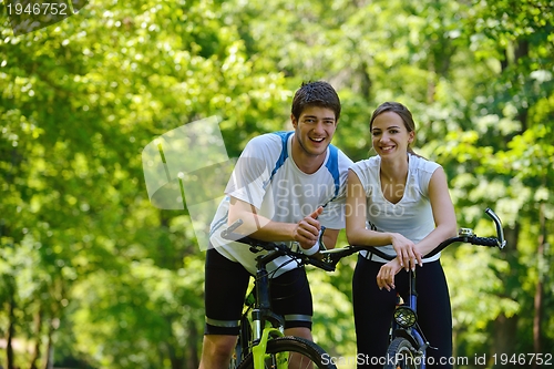 Image of Happy couple ridine bicycle outdoors