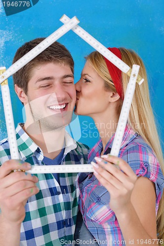 Image of happy couple paint wall at new home