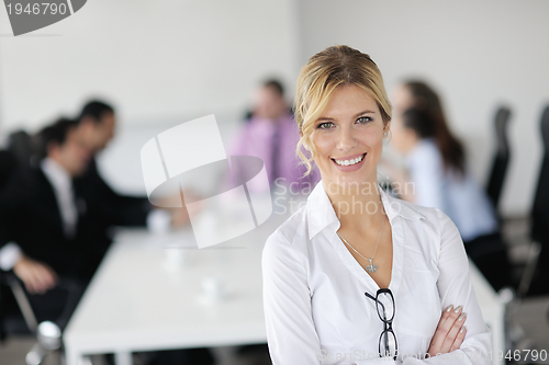 Image of business woman standing with her staff in background