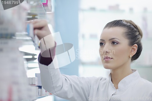 Image of pharmacist chemist woman standing in pharmacy drugstore