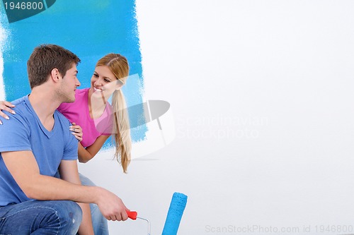 Image of happy couple paint wall at new home