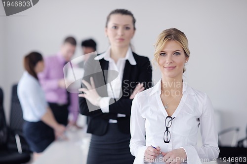 Image of business woman standing with her staff in background