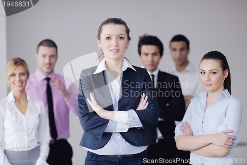 Image of business woman standing with her staff in background