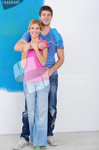 Image of happy couple paint wall at new home