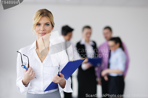 Image of business woman standing with her staff in background