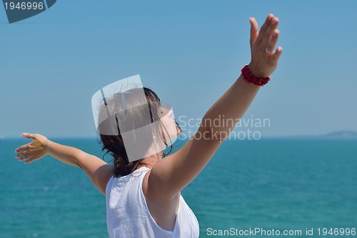 Image of happy young woman with spreading arms to sky