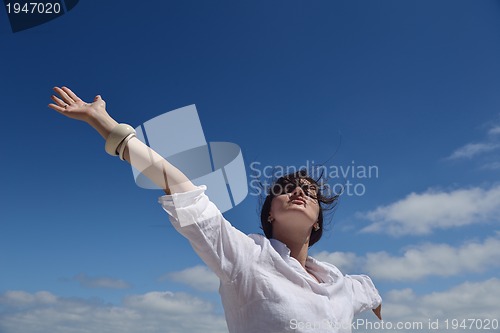 Image of happy young woman with spreading arms to sky