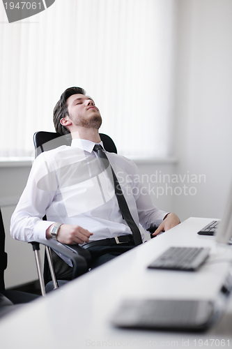 Image of tired and depresed young business man at office