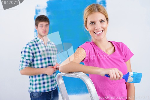 Image of happy couple paint wall at new home