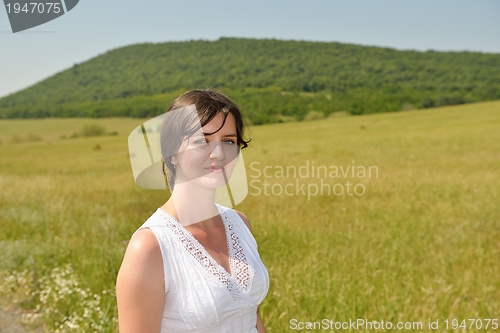 Image of Young happy woman in green field