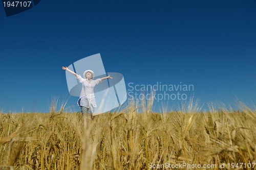 Image of young woman in wheat field at summer