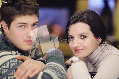 Image of Young romantic couple sitting and relaxing in front of fireplace