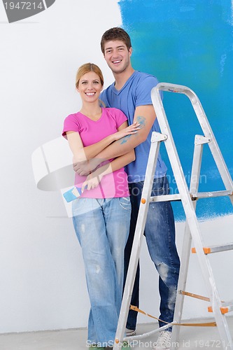 Image of happy couple paint wall at new home
