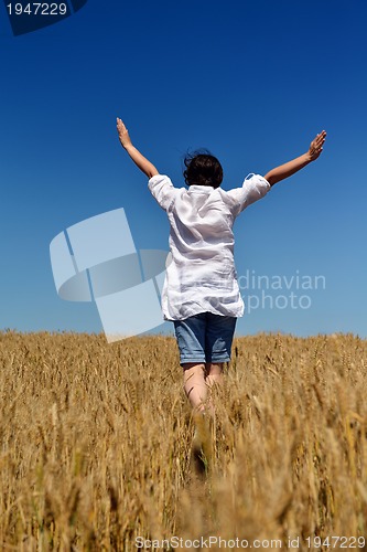 Image of young woman in wheat field at summer