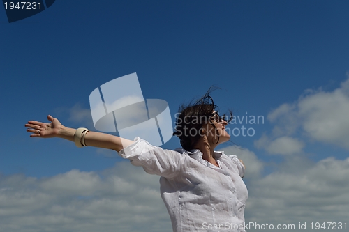 Image of young woman with spreading arms to sky