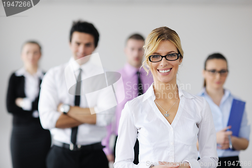 Image of business woman standing with her staff in background