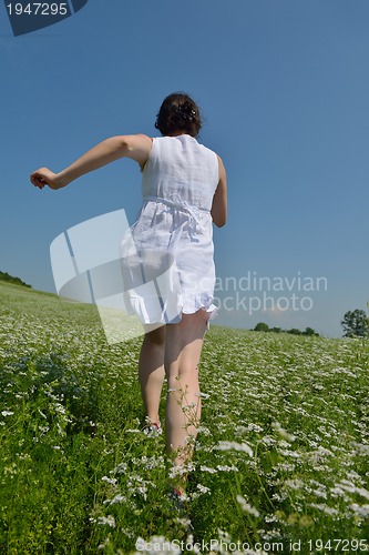Image of Young happy woman in green field