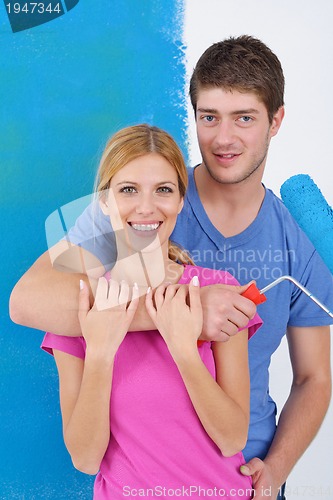 Image of happy couple paint wall at new home