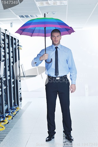 Image of businessman hold umbrella in server room