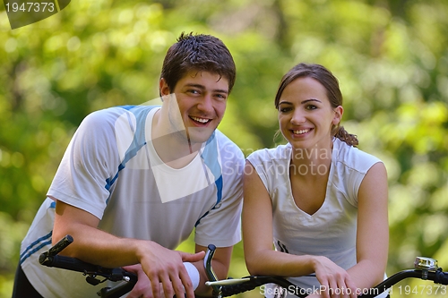 Image of Happy couple ridine bicycle outdoors