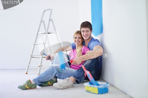 Image of happy young cople relaxing after painting in new home