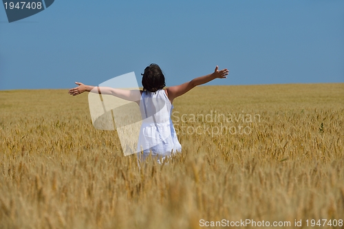 Image of young woman in wheat field at summer