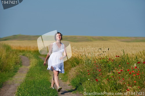 Image of young woman in wheat field at summer