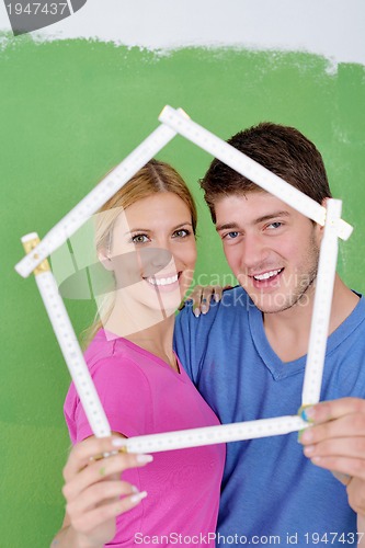 Image of happy couple paint wall at new home