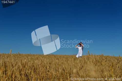 Image of young woman in wheat field at summer