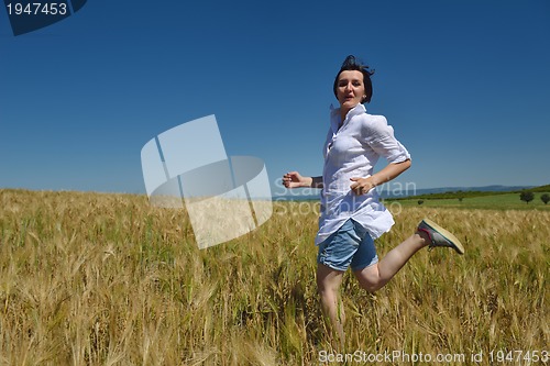 Image of young woman in wheat field at summer