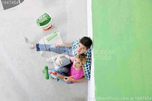 Image of happy young cople relaxing after painting in new home