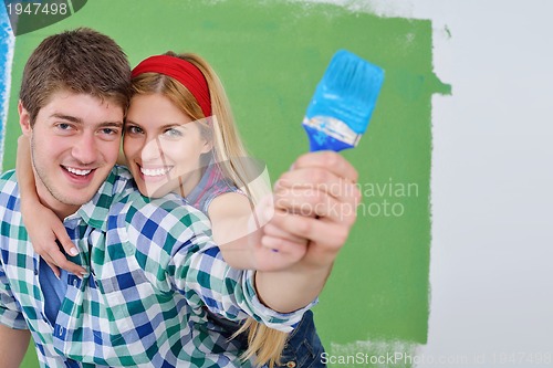 Image of happy couple paint wall at new home