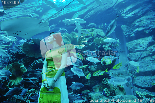 Image of young woman with big aquarium in backgrond