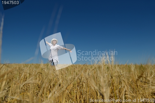 Image of young woman in wheat field at summer