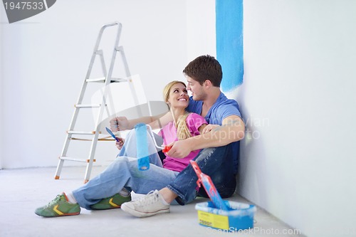 Image of happy young cople relaxing after painting in new home