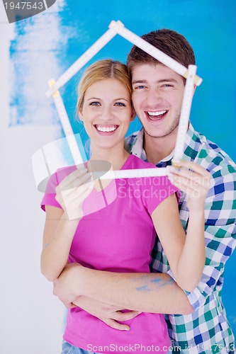 Image of happy couple paint wall at new home