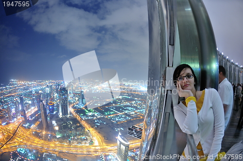 Image of beautiful woman portrait with big city at night in background