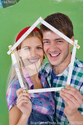 Image of happy couple paint wall at new home