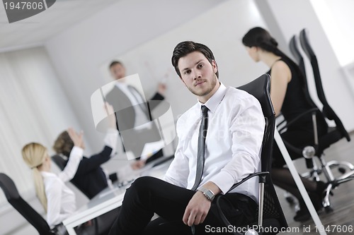 Image of handsome young business man with colleagues in background