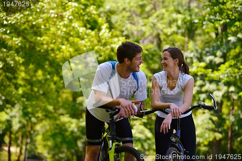 Image of Happy couple ridine bicycle outdoors