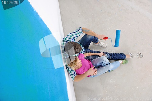 Image of happy young cople relaxing after painting in new home