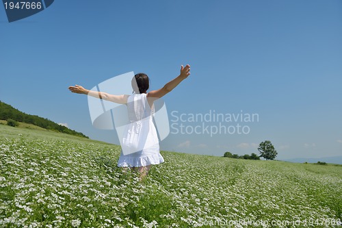 Image of Young happy woman in green field