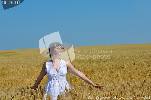 Image of young woman in wheat field at summer