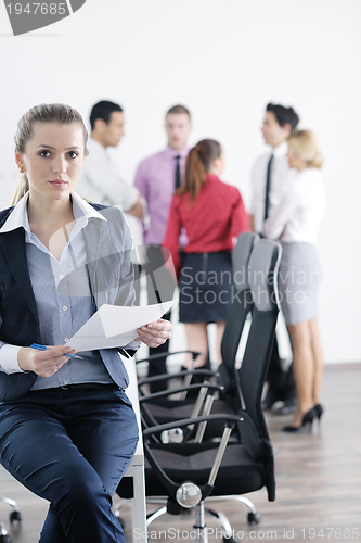 Image of business woman standing with her staff in background