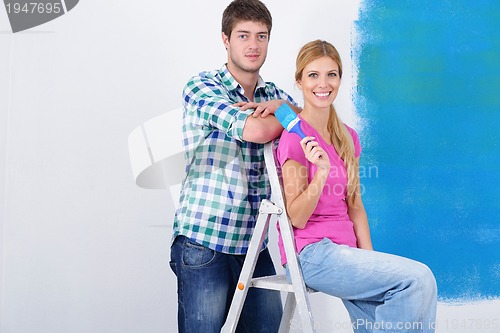 Image of happy couple paint wall at new home