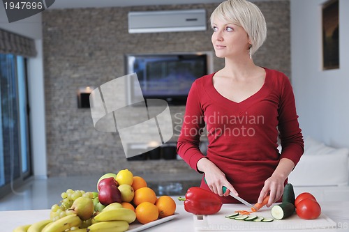 Image of happy  beautiful blonde  woman prepare food in  the kitchen